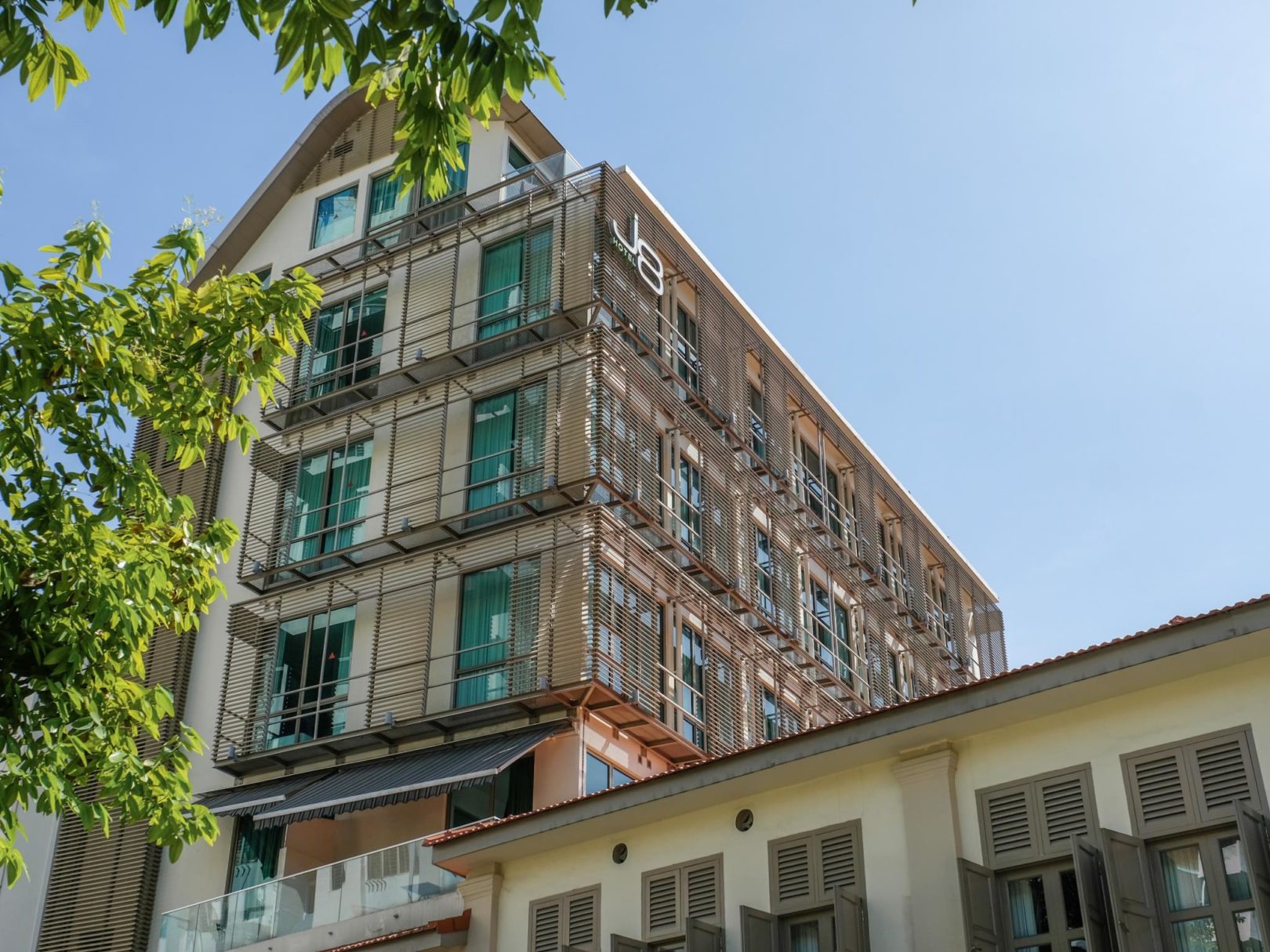 An exterior building picture of J8 Hotel with a balcony.